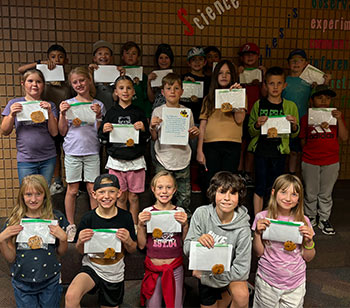 Students showing their letters and cookies for Firefighters