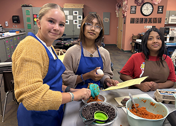 Three happy girls making a culinary treat