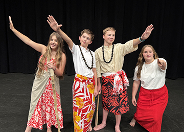 sidebargraphic_Programs Student actors performing on stage in Hawaiian attire