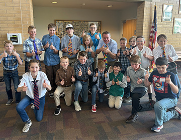 students with thumbs up and most wearing neckties