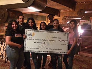 Students holding a large check