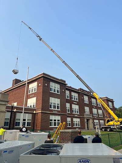 crane lifting something  on a building