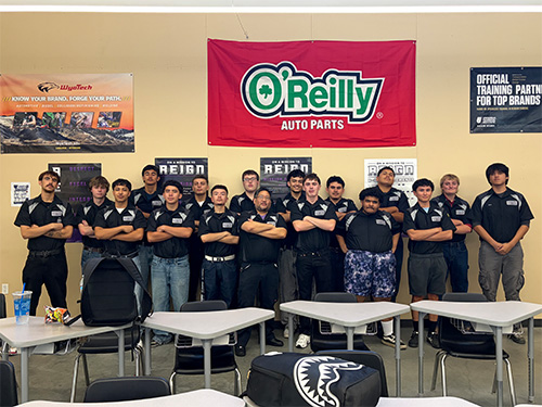 Student group photo under an O'Reilly Auto Parts sign