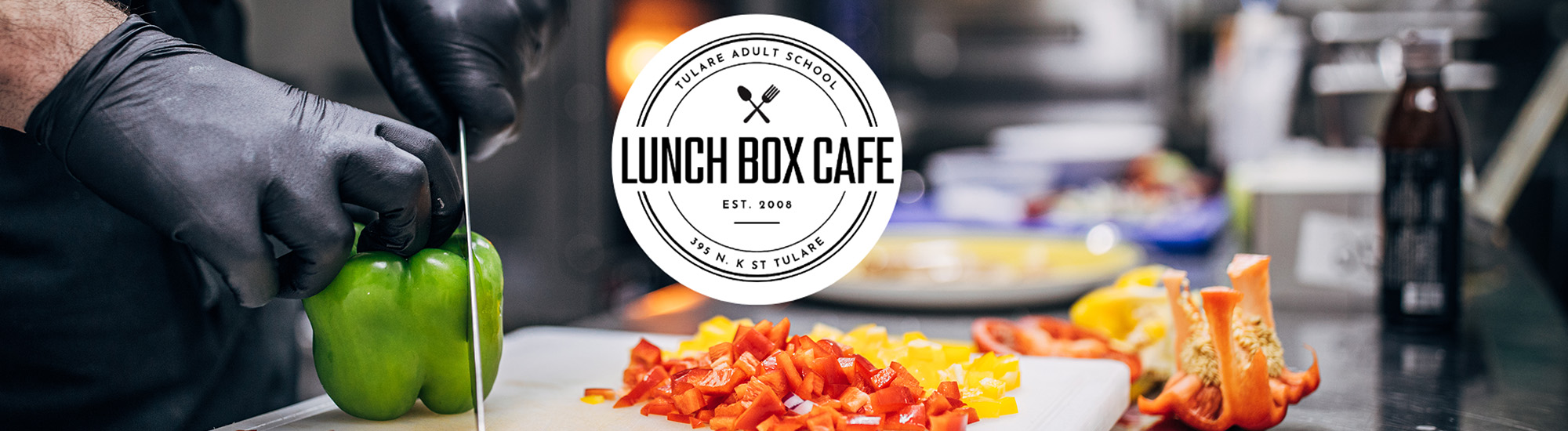 person chopping food with Lunch Box Cafe logo
