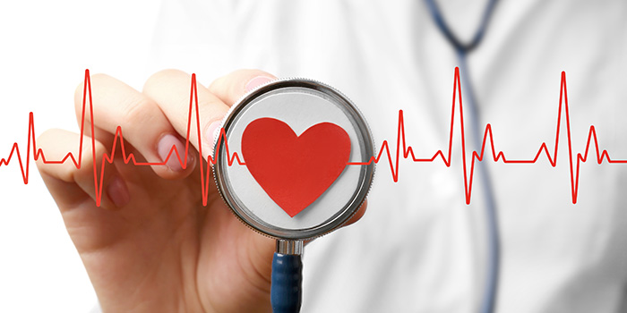 Nurse holding up a stethoscope with a red heart