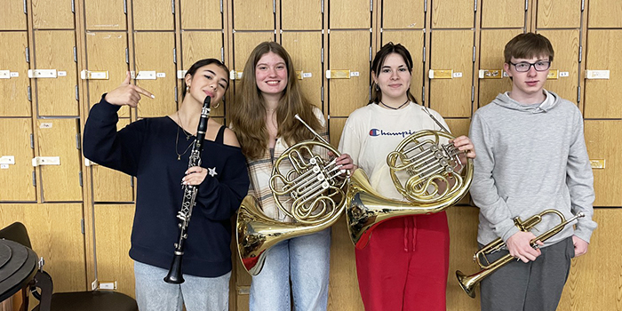 Four students posing for a picture that were selected for the Umass Amherst Honors Band Festival