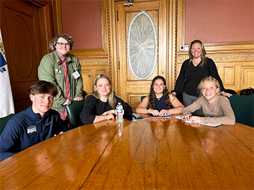 Students and teachers around a conference table