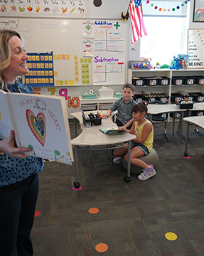Teacher reading a book to her students in the classroom