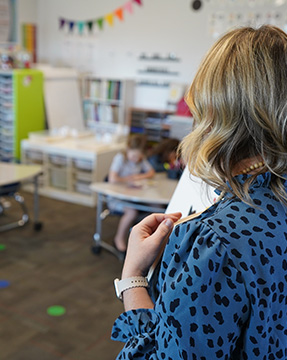 Teacher in blue dress reading a book to her class