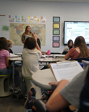 Teacher in front of class talking to her students