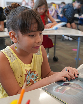 Elementary school girl reading a book