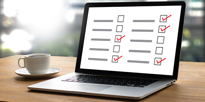 Laptop with online survey on desk with cup of coffee
