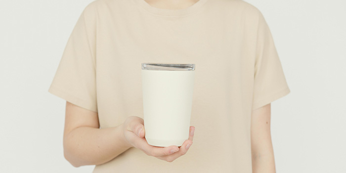 Mockup of person in a tee shirt holding a drink tumbler