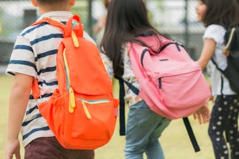 students walking away with backpacks on