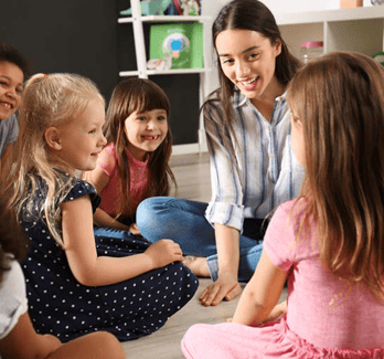 teacher and students on the floor in a classroom