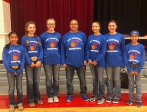 Adults and students with basketball themed shirts