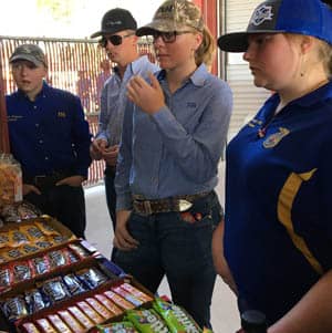 Adults and students standing in front of a candy fundraising table