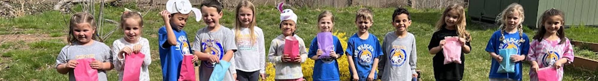 group of smiling students with bags and bunny hats