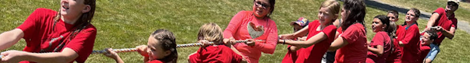 students in red shirts playing tug of war