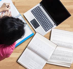 Student working on homework at home with laptop