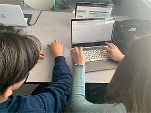 Students working on laptop computer together