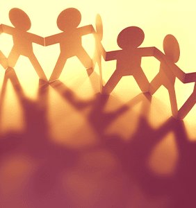 Paper chain people at sunset with long shadows