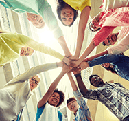 kids wearing colorful clothes, standing in a circle with hands in