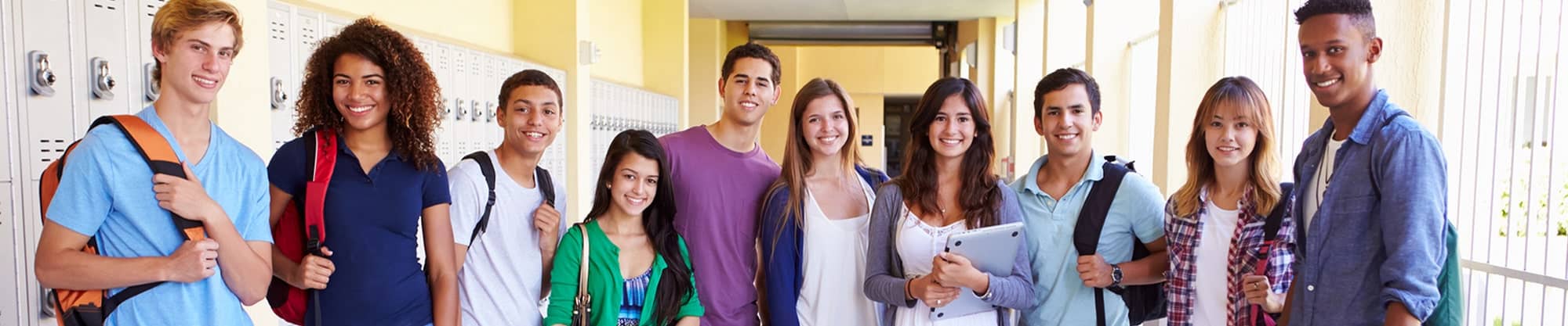 Group of high school students with backpacks standing in front of lockers