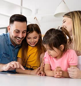Parents helping children on a tablet