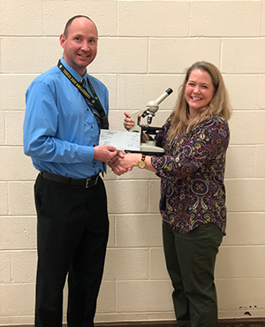Tom Baker, principal, presents a PARSS grant check to Nicole Keller, biology teacher.