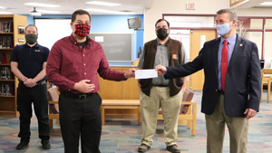 Superintendent Bill Vonada presents the check from the PARSS grant to the recipients. From left to right: Dan O’Brien, Colin Milne, Zack Bedee, and Bill Vonada. Not pictured: Gayle Mitchell. (photograph by Ava Fischer)