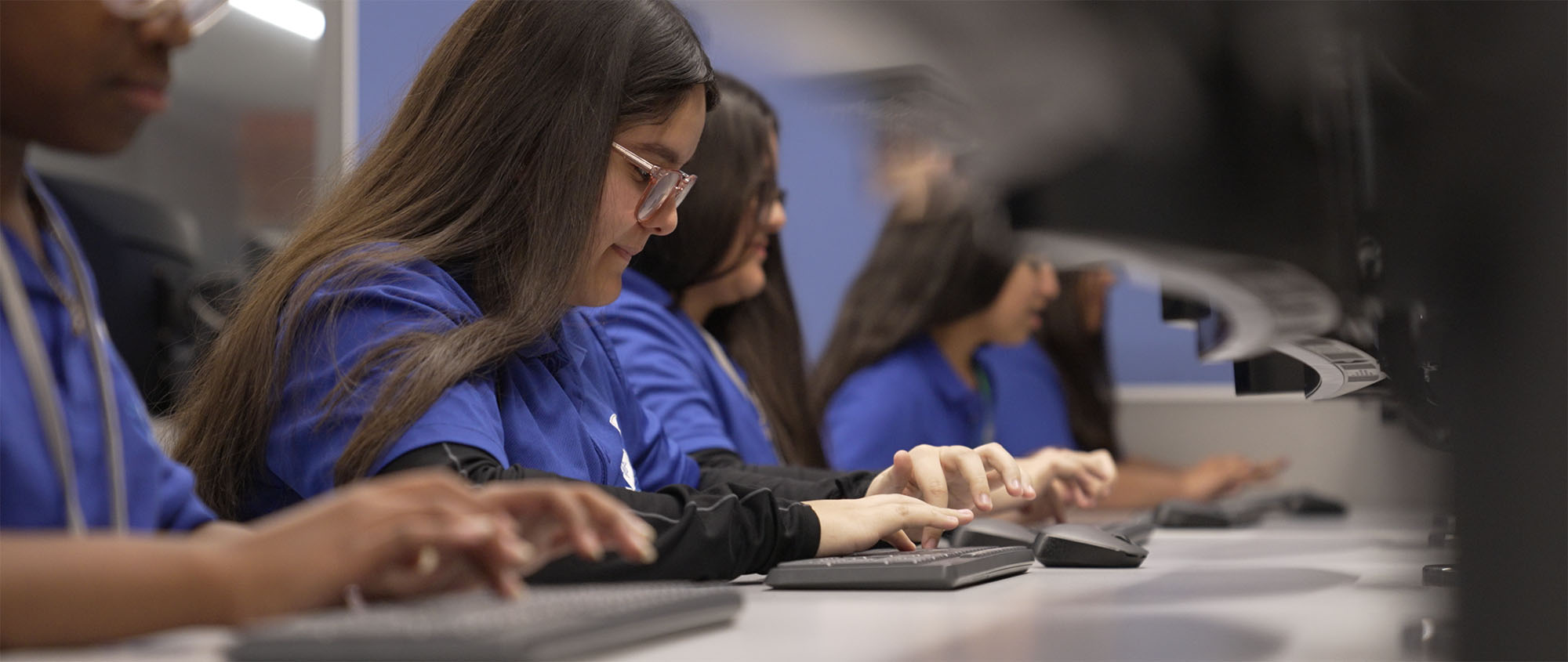 cafeteria students sitting at computers typing