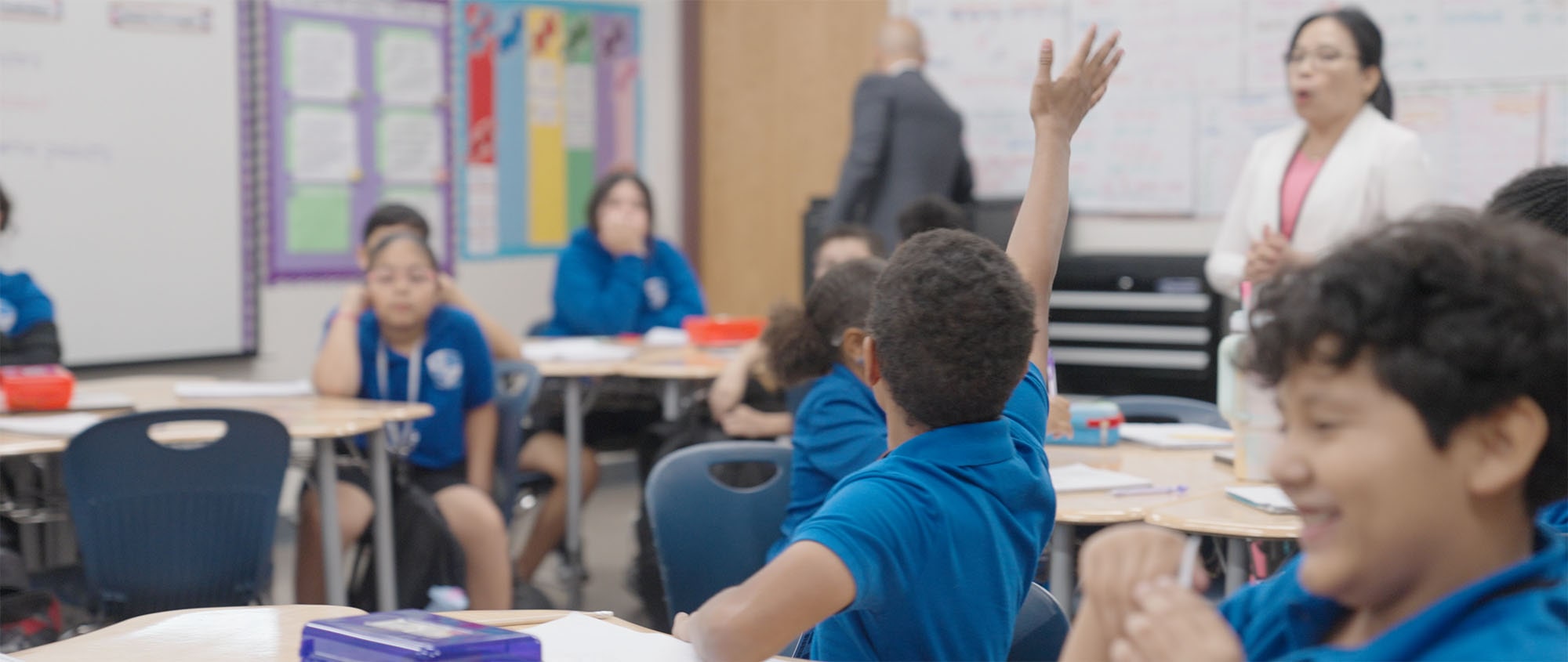 cafeteria student raising hand in the classroom