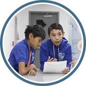 two students sitting at desk going over assignment
