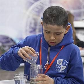 student pouring liquied into a beaker