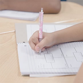 student writing in a notebook