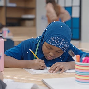 student sitting at table writing