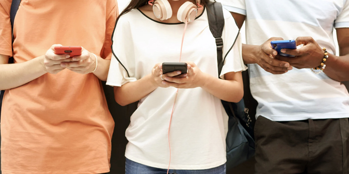 Three students using their mobile phones