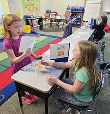 Two female students reading to each other