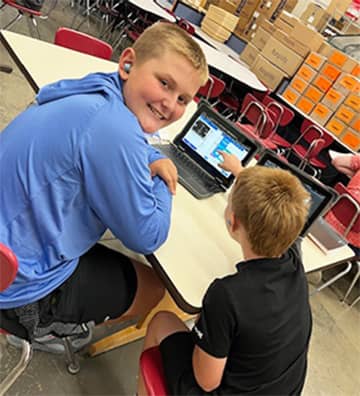 Two students working on a laptop
