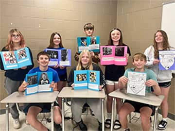 Students holding artwork