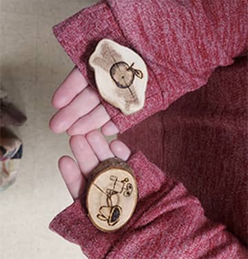 Student holding wood burning project