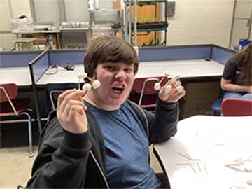 Student holding art project
