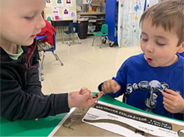 Two students looking at a worm