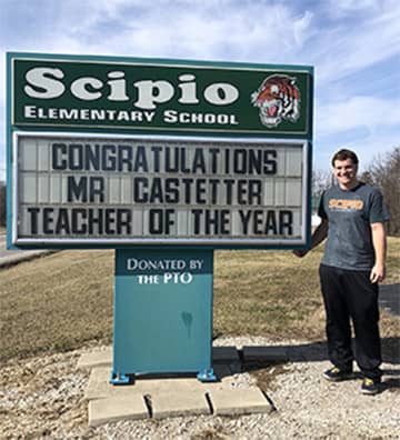 Mr. Castetter in front of his teacher of the year sign