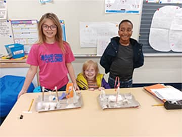 Three students with art projects
