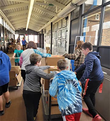 Students pushing carts down a hallway