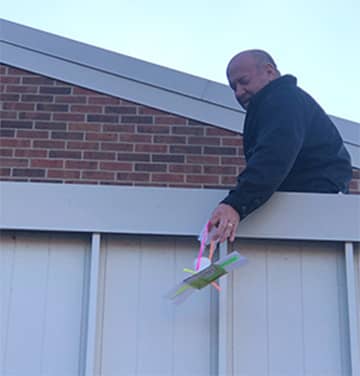 Man lifting something over a fence