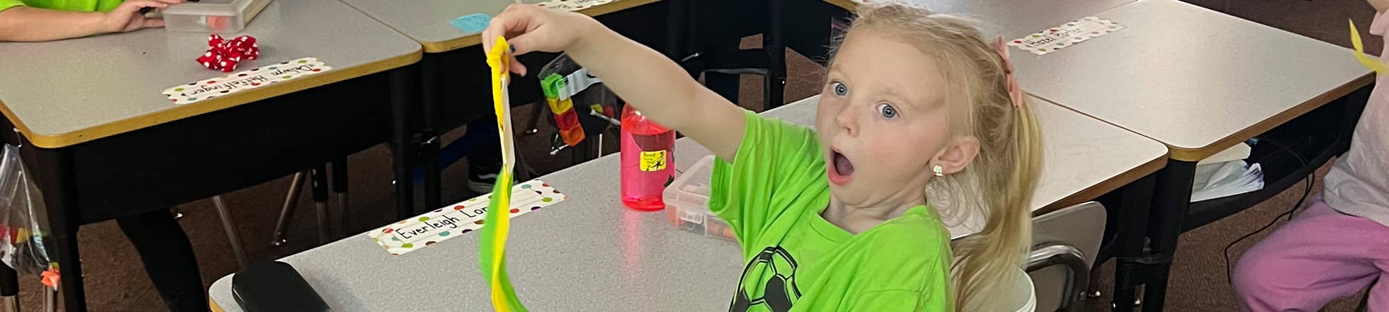 A surprised student holding up a ribbon