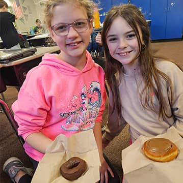 two students with donuts